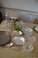Wide view of assortment of glass and silver plated serving pieces on table