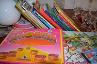 Photo shows a stack of Italian children's and cookbooks alongside two Italian bingo games, including the Somorfia game by Clementoni in a pink box and a Tombola bingo game with components laid out.