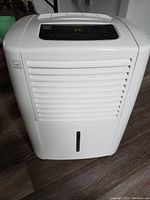 Front view of white Kenmore dehumidifier showing air vent grille and water collection tank slot.