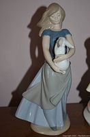 Front view of the Lladro figurine showing the girl in blue and gray holding a white rabbit.