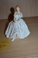 Front view of the Royal Doulton Heather figurine showing detailed porcelain figure of seated woman in white dress.