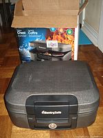 Closed medium size SentrySafe chest in front of original box showing product image and branding.