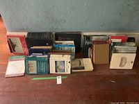 Front view of all books arranged in two low rows on the floor against a wall