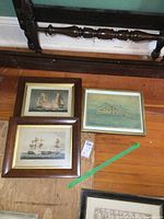 Overhead view of three framed nautical artworks laid on wooden floor