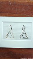 Two ink sketches of pedestal statues side by side in mat