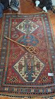Full view of geometric patterned rug with carpet beater on top