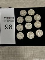 Lot of 11 Washington quarters on black background with MaxSold number tag visible.