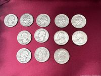 Front side view of all 12 silver Washington quarters showing dates and George Washington profile.
