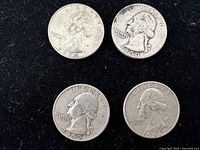 Four Washington Quarters laid out on black background showing obverse side with dates 1950, 1952-D, 1954, and 1961-D.