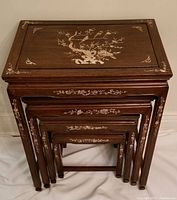 Top view of all 4 nesting tables stacked showing detailed mother-of-pearl inlay on the largest with floral and bird design.
