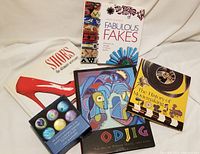 All four books and boxed set of Tiffany Favrile glass magnets shown together on white fabric background.