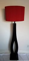 Full front view of floor lamp showing base and red shade