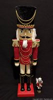 Front view of large and small nutcracker dolls showing detailing and size difference