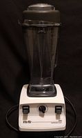 Full front view of the Vita-Mix 5000 blender showing the clear container on top of the white base unit with controls and logo.
