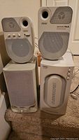 Four-piece Juster multimedia speaker set with two Active 95A speakers and two subwoofers. Cream colored units with mesh fronts.