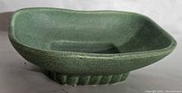 Side view showing textured green glaze and ribbed foot on the soap dish.