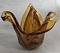 Front angled view of the amber brown ruffled vase showing glass swirl pattern and curled edges.