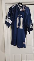 Front and side view of navy blue Dallas Cowboys jersey with number 11 and star logos on sleeves.