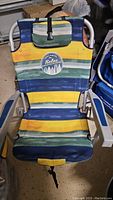 Full view of the Tommy Bahama foldable beach chair showing striped fabric and metal frame.