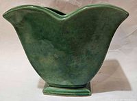 Side profile photo showing the tulip-shaped green ceramic planter with smooth glaze, no visible chips or cracks.