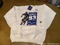 Full view of white sweater with large front graphic showing hockey player Gilmour and number 93 with Maple Leafs emblem.