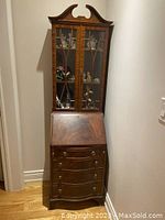 Full view of two-piece mahogany secretary desk with upper glass-front cabinet and lower drawer section