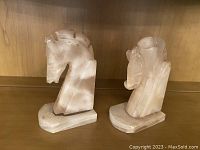 Front angle view showing the two marble horse head bookends with visible chips on horse ears and the base glued back.