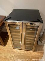 Front view showing dual glass doors with stainless steel frame, bar handles and digital control panels