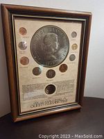 Framed display upright showing all coins and printed background
