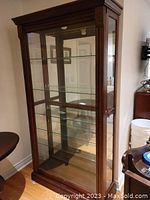 Full front view of curio cabinet showing glass doors and shelves