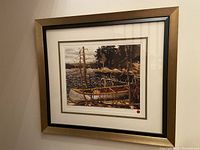 Framed limited edition print of Tom Thomson's The Canoe hung on wall, showing full artwork and frame