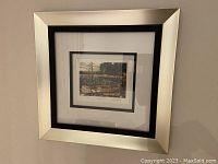 Framed and matted reproduction print of Tom Thomson's The Canoe 1912 showing entire framed artwork hung on wall.