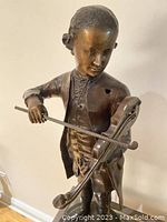 Close-up of the violinist's upper body showing face, violin, and bow