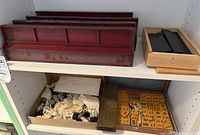 Four dark red wooden Mahjong racks on a shelf with a small wooden box beside them