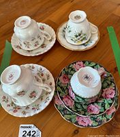 Four Royal Albert tea cups and saucers arranged upside down showing floral patterns and gold trim.