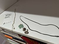 Overview of all items: one necklace, jade pendant, and two screw-back earrings.