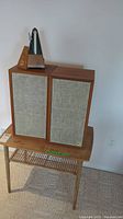 Overall display: side table topped with two speakers and metronome