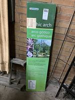 Photo of boxed Gardman Gothic arch metal trellis kit standing against a brick wall.