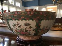Exterior view of porcelain bowl on wooden stand showing overall decoration and condition