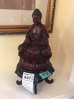 Front view of seated Buddha figure on black stand with measurement label 15x8 visible.