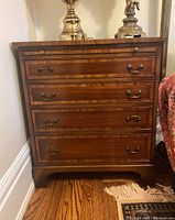 Front view of nightstand showing four drawer fronts and overall form
