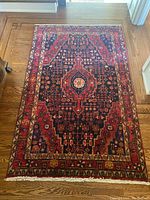 Full top-down view of rug laid on hardwood floor, showing overall pattern and condition