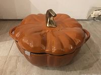 Top view of orange pumpkin-shaped ceramic cocotte with lid