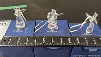 Three Swarovski crystal angels displayed on blue boxes with a ruler showing approx. 3.5 inches tall