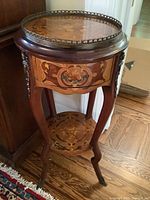 Front three-quarter view showing top inlay, drawer front and lower shelf