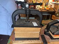 Front view of cast iron book press with particleboard boards