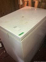 Full view of white chest freezer showing top and sides, with visible stains and dirt marks.