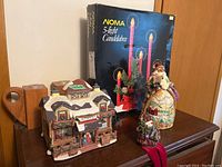 Noma 5-light candelabra box with ceramic holiday figurines on table