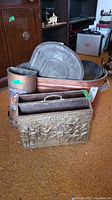 Wide view of lot showing copper trough with lid and handles, embossed magazine rack, cast iron pot and cylindrical bath apparatus