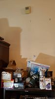 Wide shot of assorted boxed light bulbs and batteries on a shelf against a wall.